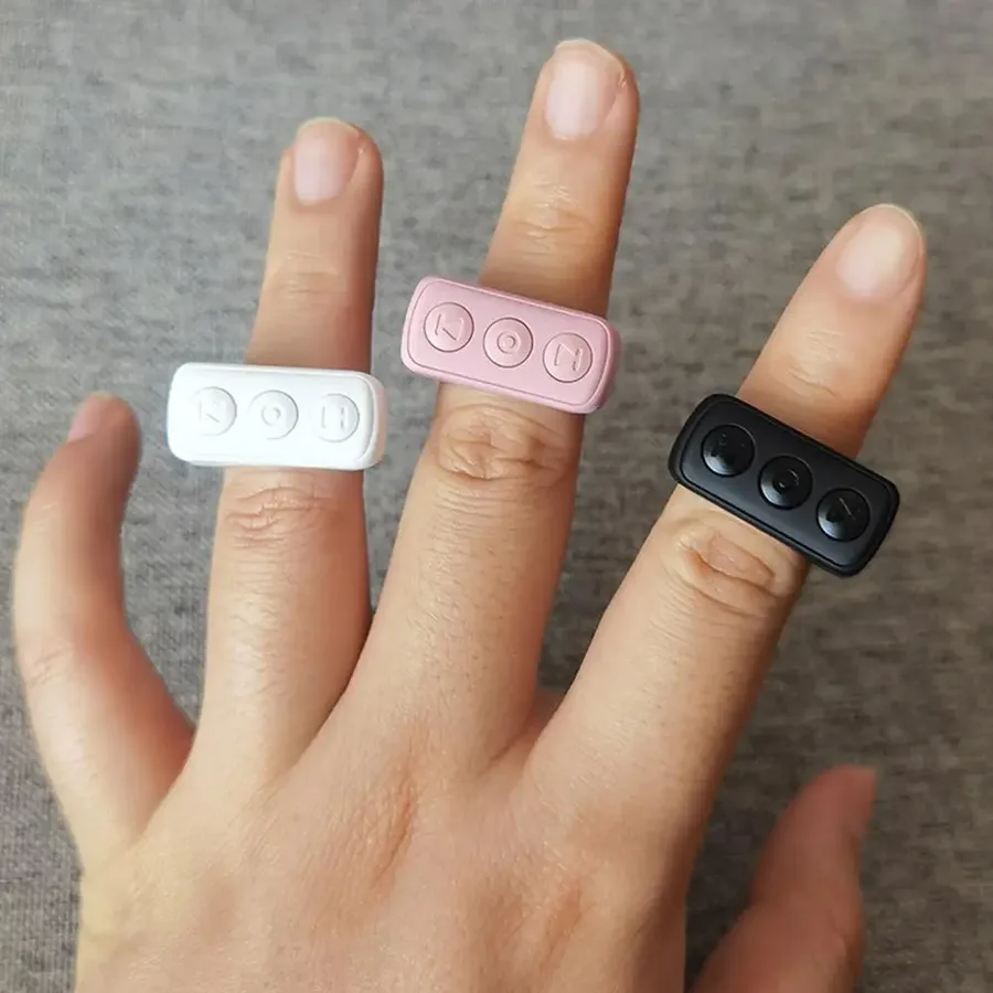 Three ScrollyRings, white, pink and black, worn on fingers